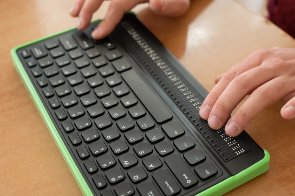 dettaglio di tastiera con tasti in linguaggio braille, usata da una persona ipovedente